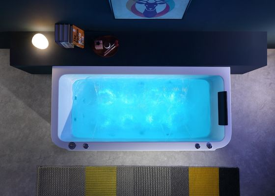 Une baignoire de massage avec tablier intégré et robinet de cascade en chrome autonome